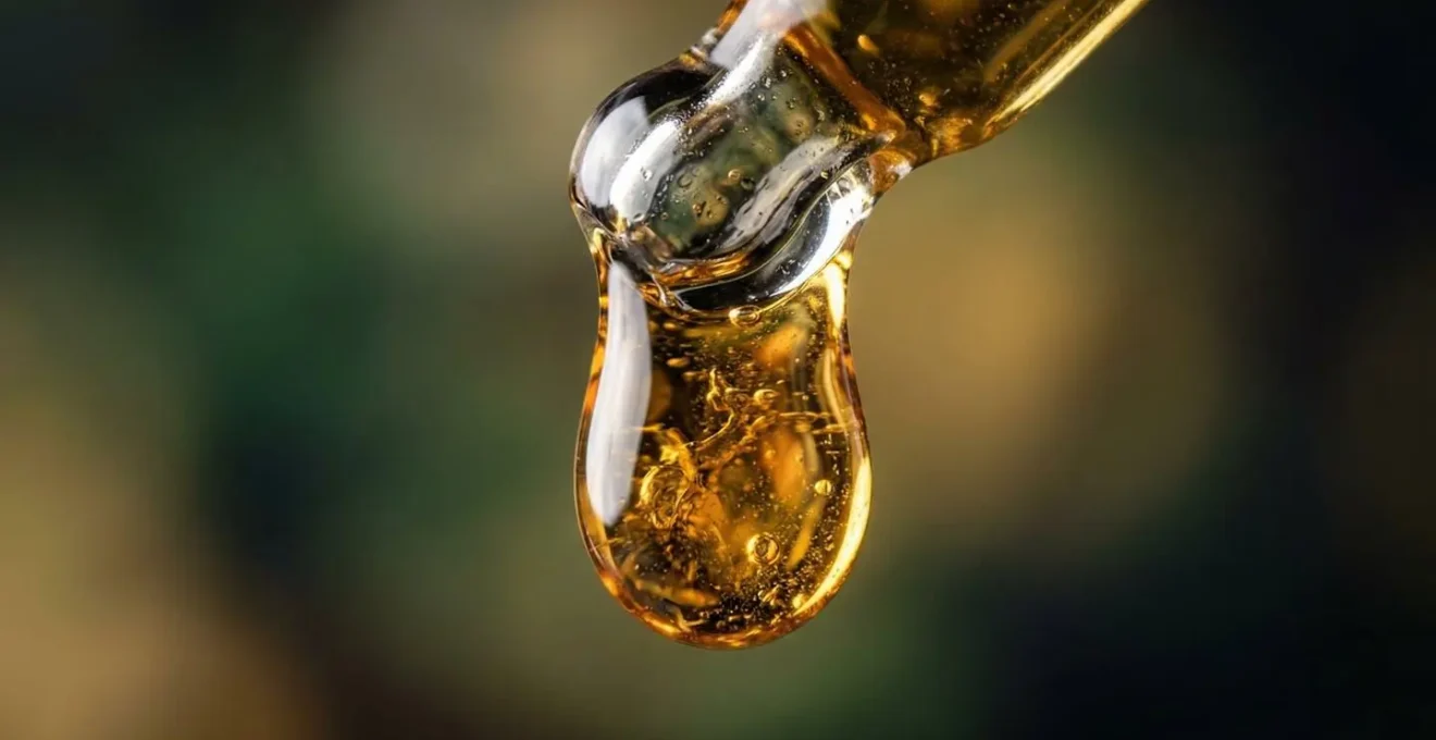 Vue macro de gouttes d'huile CBD avec texture et reflets naturels